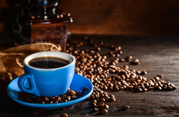 taza azul de café con granos de café